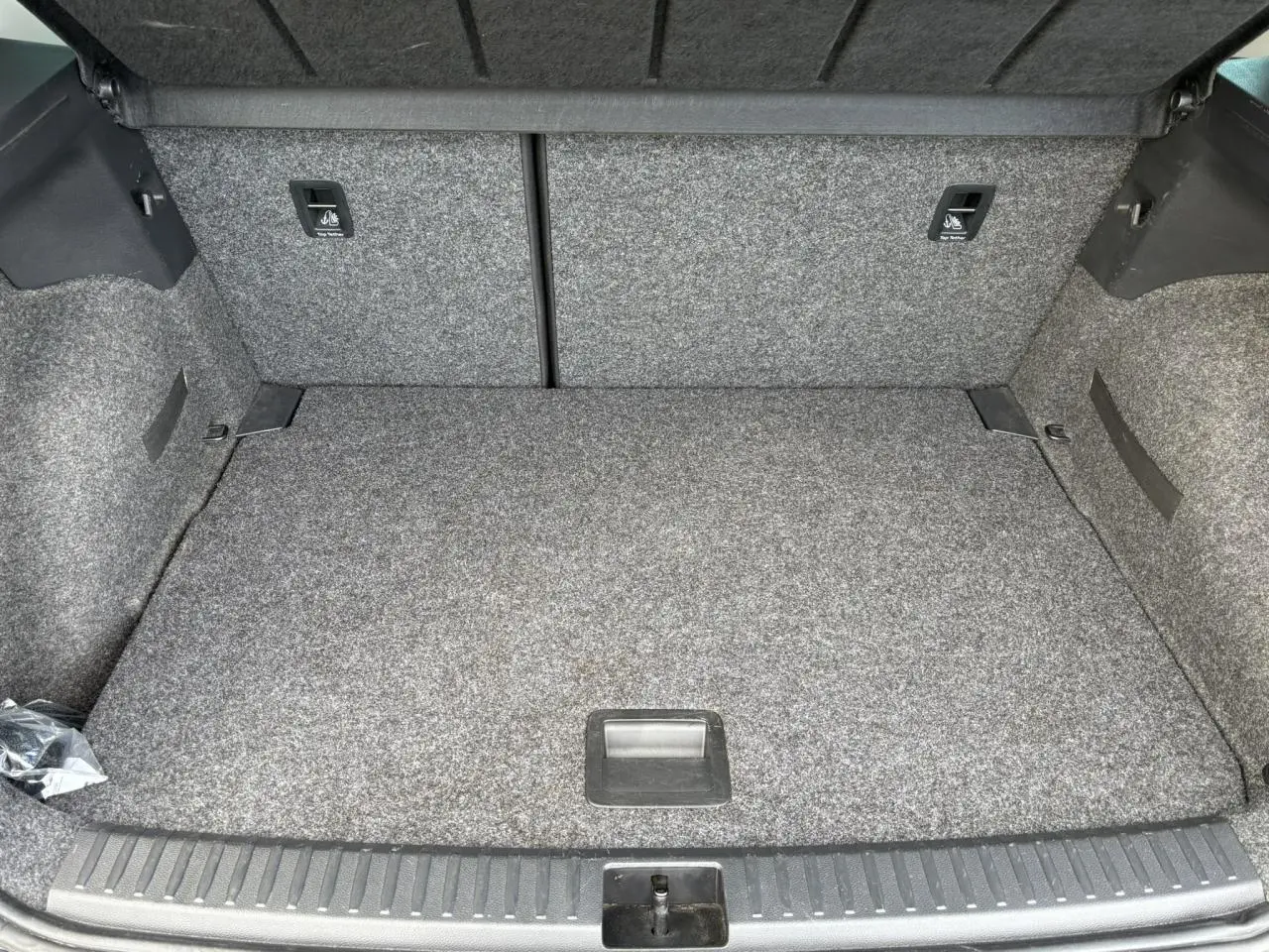 Coffre ouvert d'une SEAT Arona TSI 110 DSG Style 2020, vue intérieure avec revêtement gris et plancher plat.