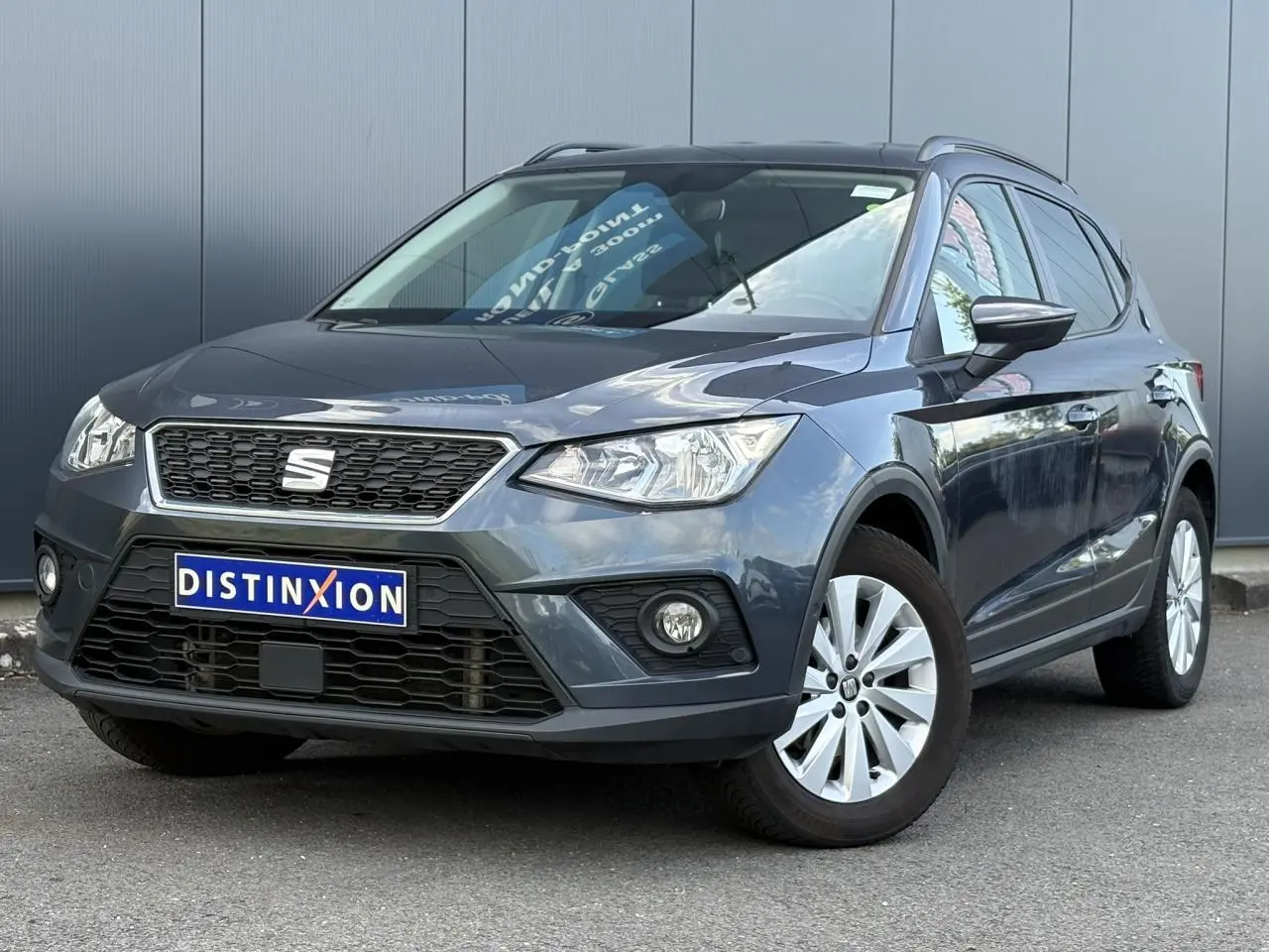SEAT Arona gris magnétique en 3/4 avant droit, avec calandre noire et jantes alliage 16 pouces.