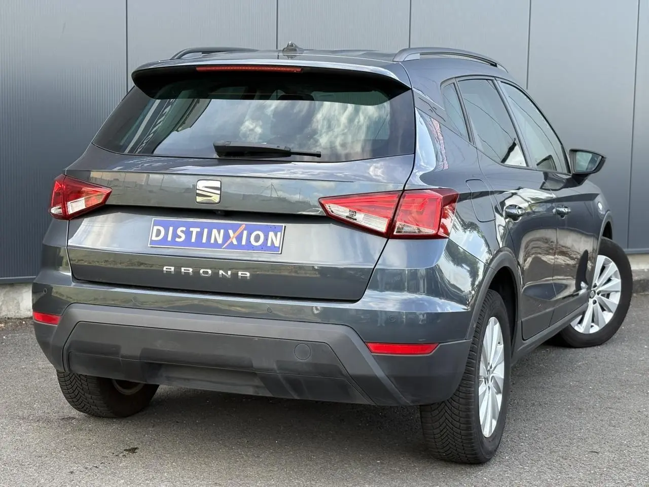 Vue 3/4 arrière droite d'un SEAT Arona gris magnétique avec feux arrière LED et jantes alliage 16 pouces.