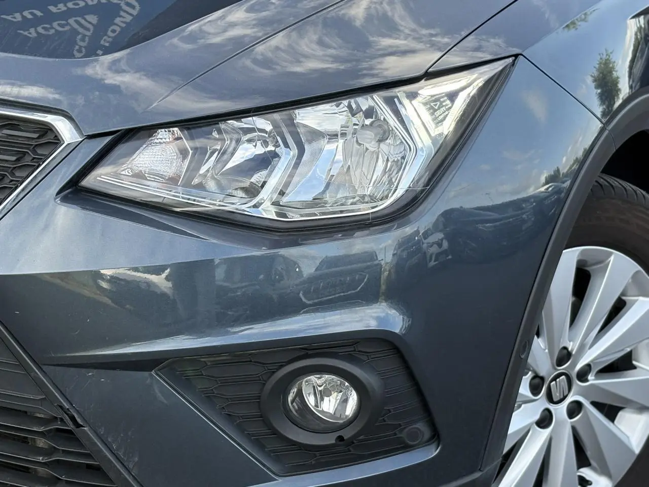 Gros plan sur l'avant droit gris magnétique du SEAT Arona 2020, mettant en valeur le phare et le feu antibrouillard.