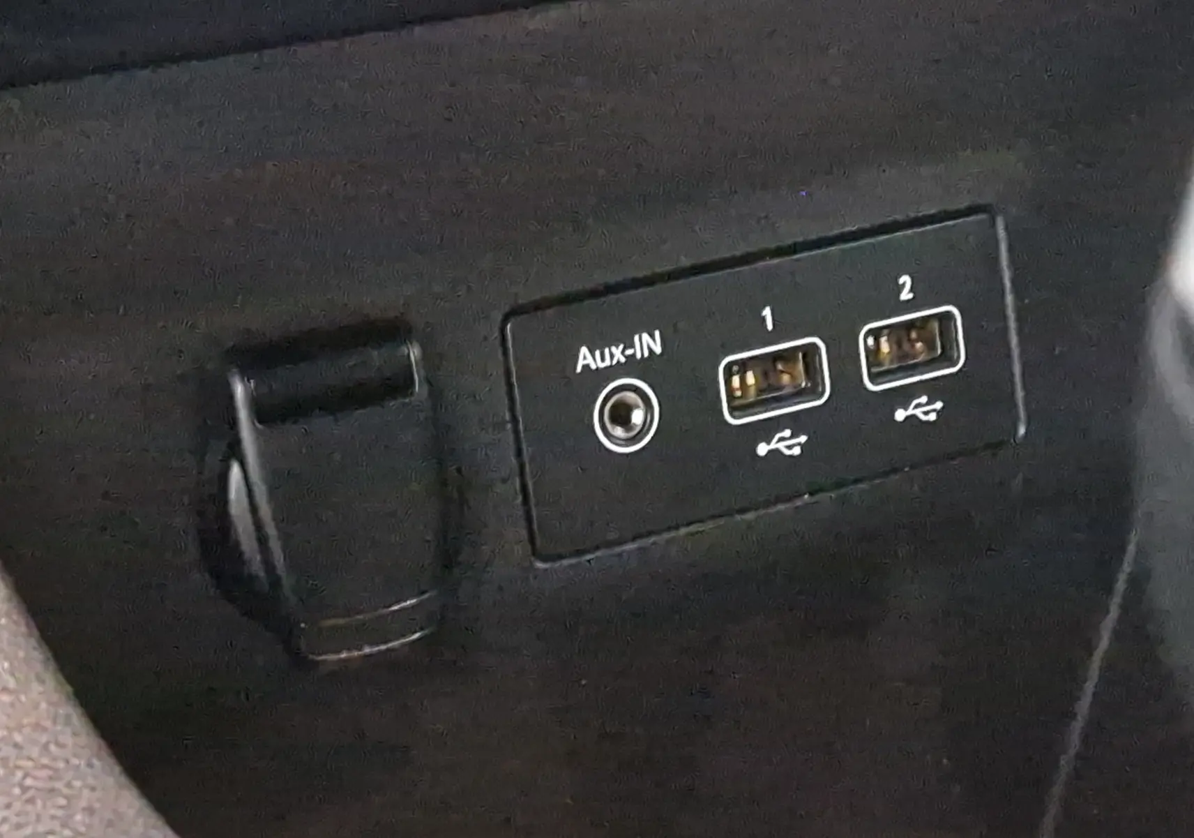 Prise auxiliaire et deux ports USB visibles sur la console centrale d'une Renault Clio V gris platine.