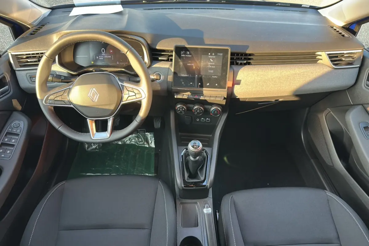 Vue intérieure avant de la Renault Clio DCI 100 Evolution 2025 avec volant multifonction et boîte manuelle.