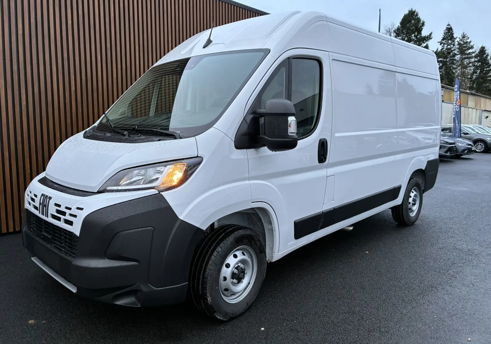 Fiat Ducato Fourgon blanc en vue 3/4 avant droit, phare allumé et pare-chocs noir contrastant visible.