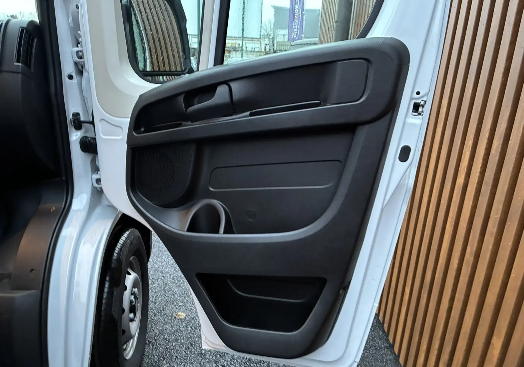 Vue rapprochée de la porte avant gauche ouverte du Fiat Ducato Fourgon blanc 2025, mettant en valeur le panneau intérieur noir.