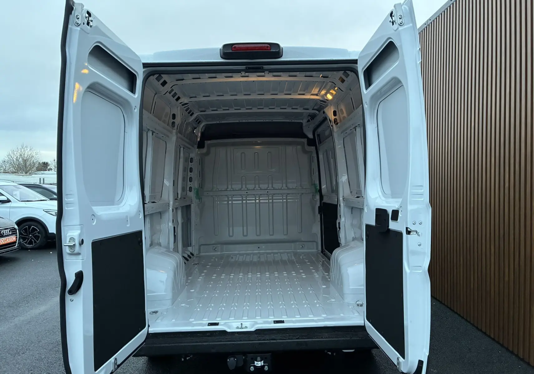 Vue arrière du fourgon blanc FIAT Ducato 2.2 140 L2H2 2025 avec portes ouvertes montrant l’espace de chargement vide.