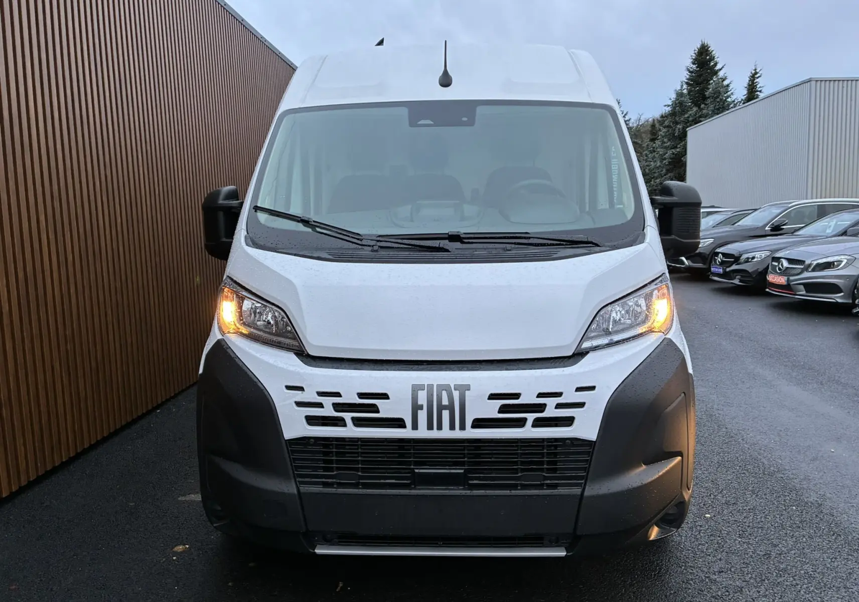 Vue de face du fourgon blanc Fiat Ducato 2.2 140 L2H2 2025 avec feux de position allumés et calandre noire distinctive.