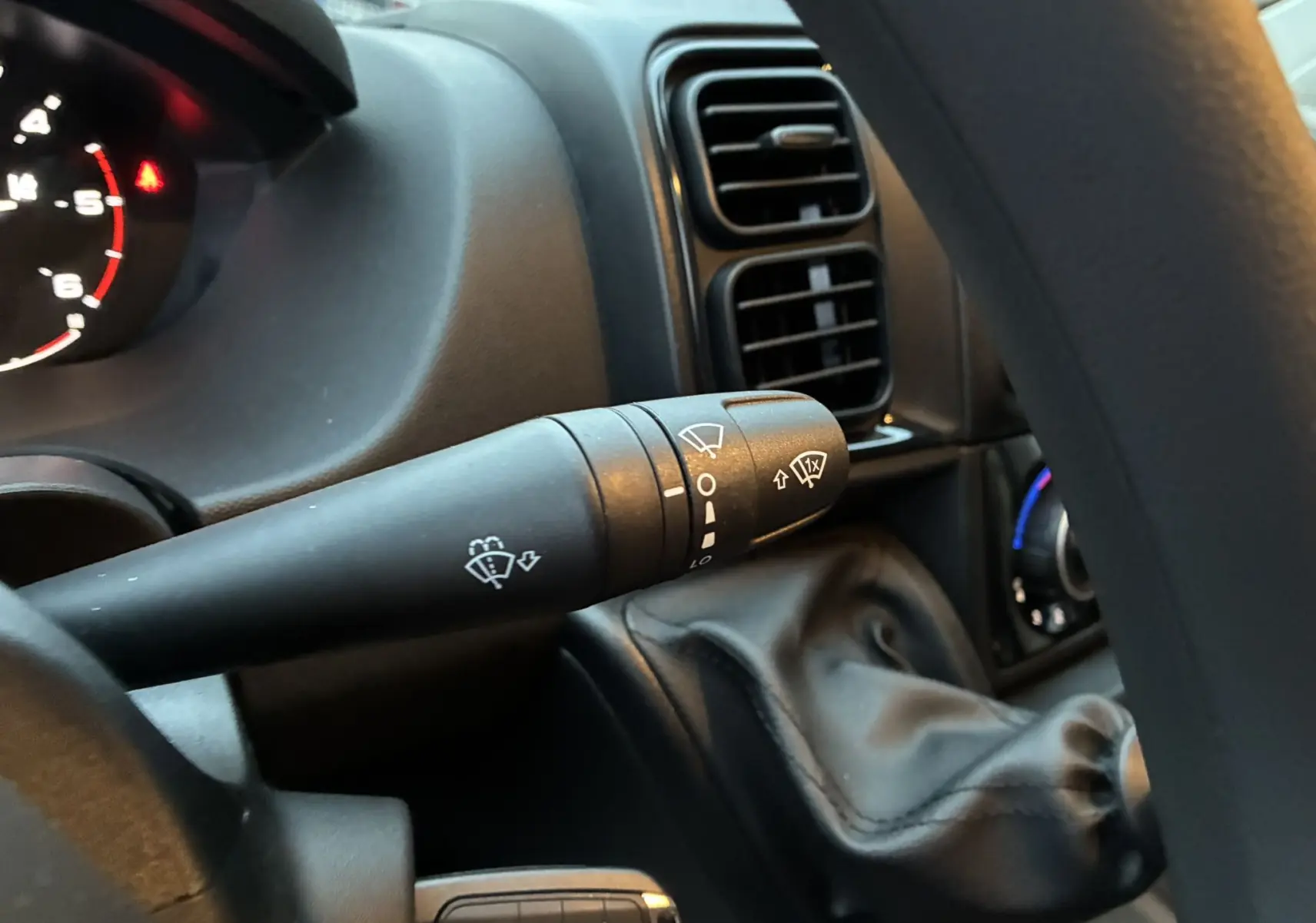 Gros plan sur la commande d’essuie-glace côté gauche du tableau de bord noir du Fiat Ducato Fourgon blanc 2025.