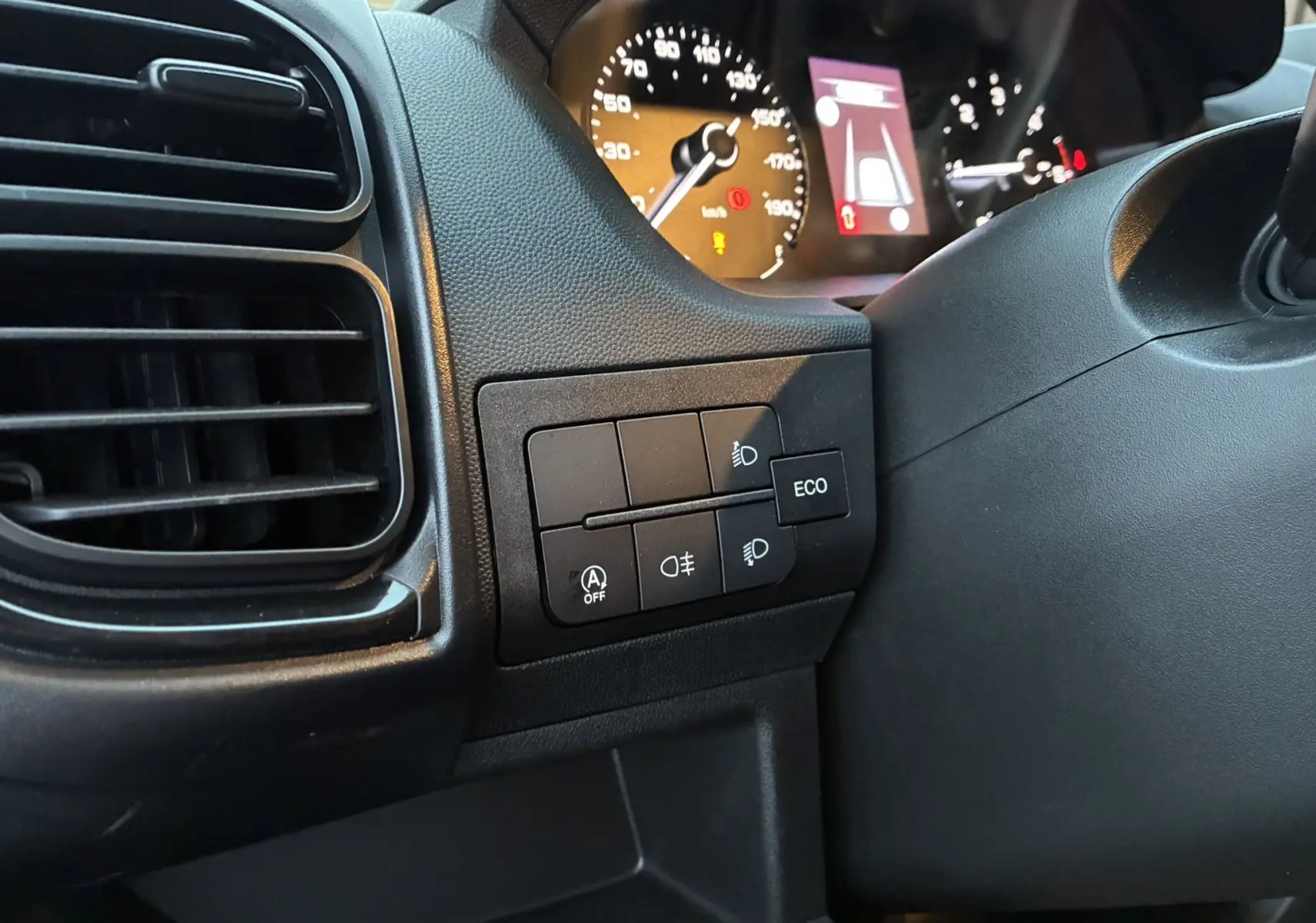 Détail du tableau de bord côté gauche du Fiat Ducato Fourgon blanc 2025, avec commandes d’éclairage et écran du compteur.