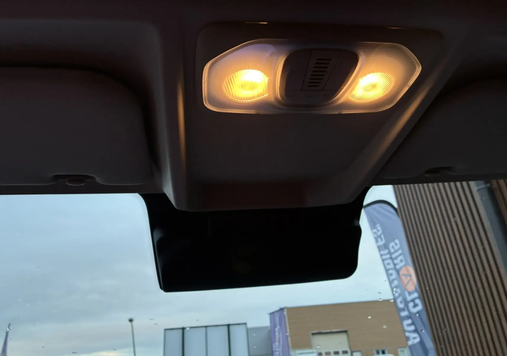 Plafonnier intérieur allumé du FIAT Ducato Fourgon blanc 2025, vue depuis l’habitacle vers le pare-brise et l’extérieur flou.