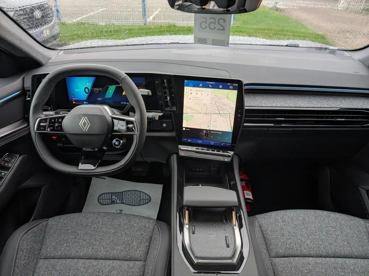 Vue intérieure avant du tableau de bord et volant du Renault Austral gris, avec écran tactile central et affichage numérique.