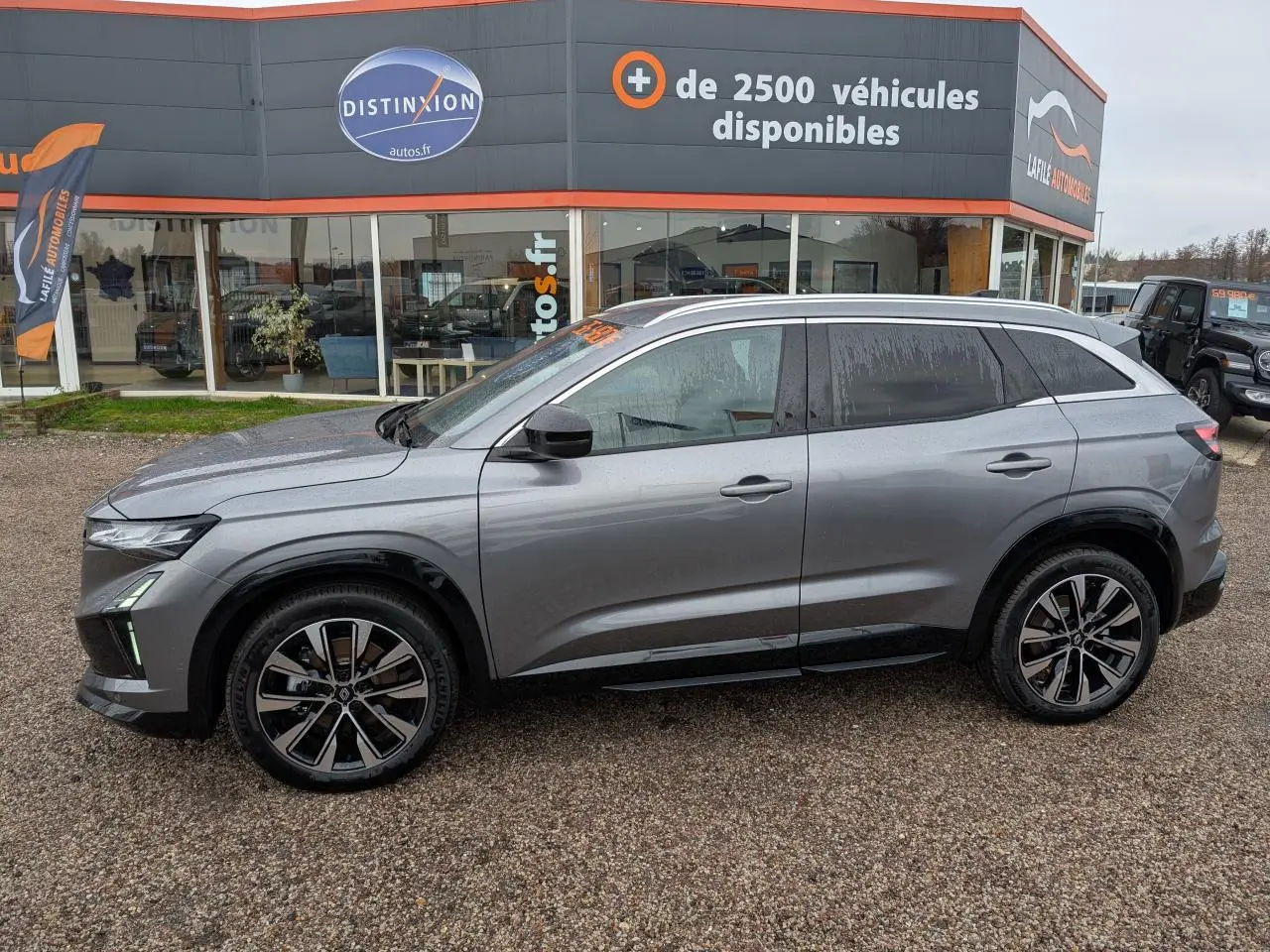 Vue de profil côté gauche d’un Renault Austral gris avec jantes alliage noires et toit panoramique.