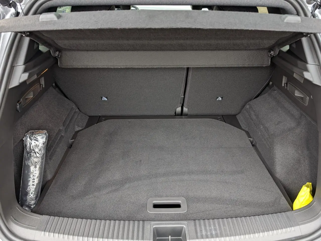 Vue intérieure du coffre du Renault Austral gris, montrant la surface de chargement avec cache-bagages et rangement latéral.