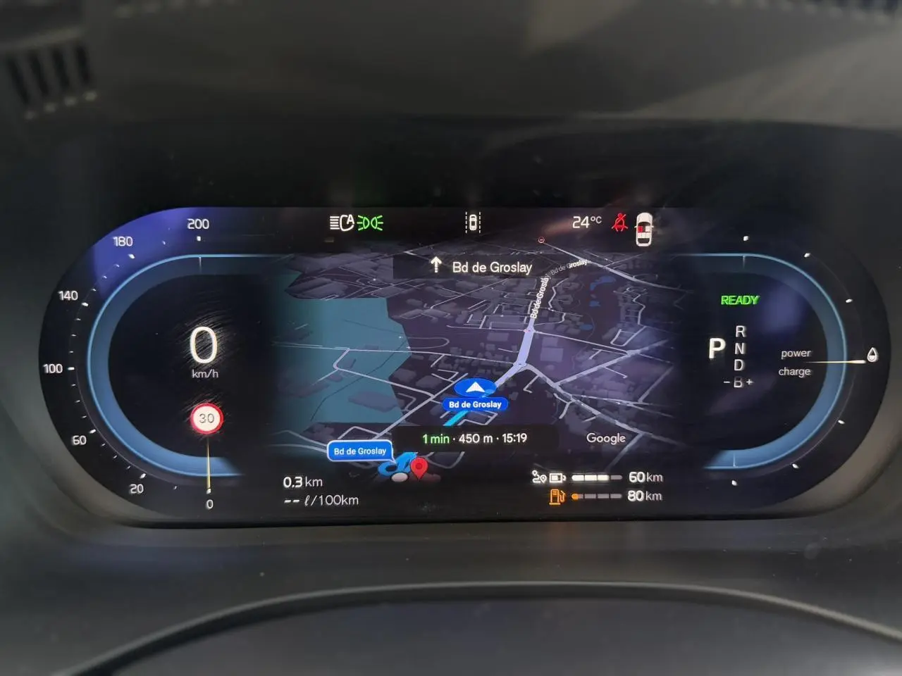 Combiné d'instruments digital du Volvo XC60 blanc, affichage navigation et vitesse à 0 km/h en vue frontale.