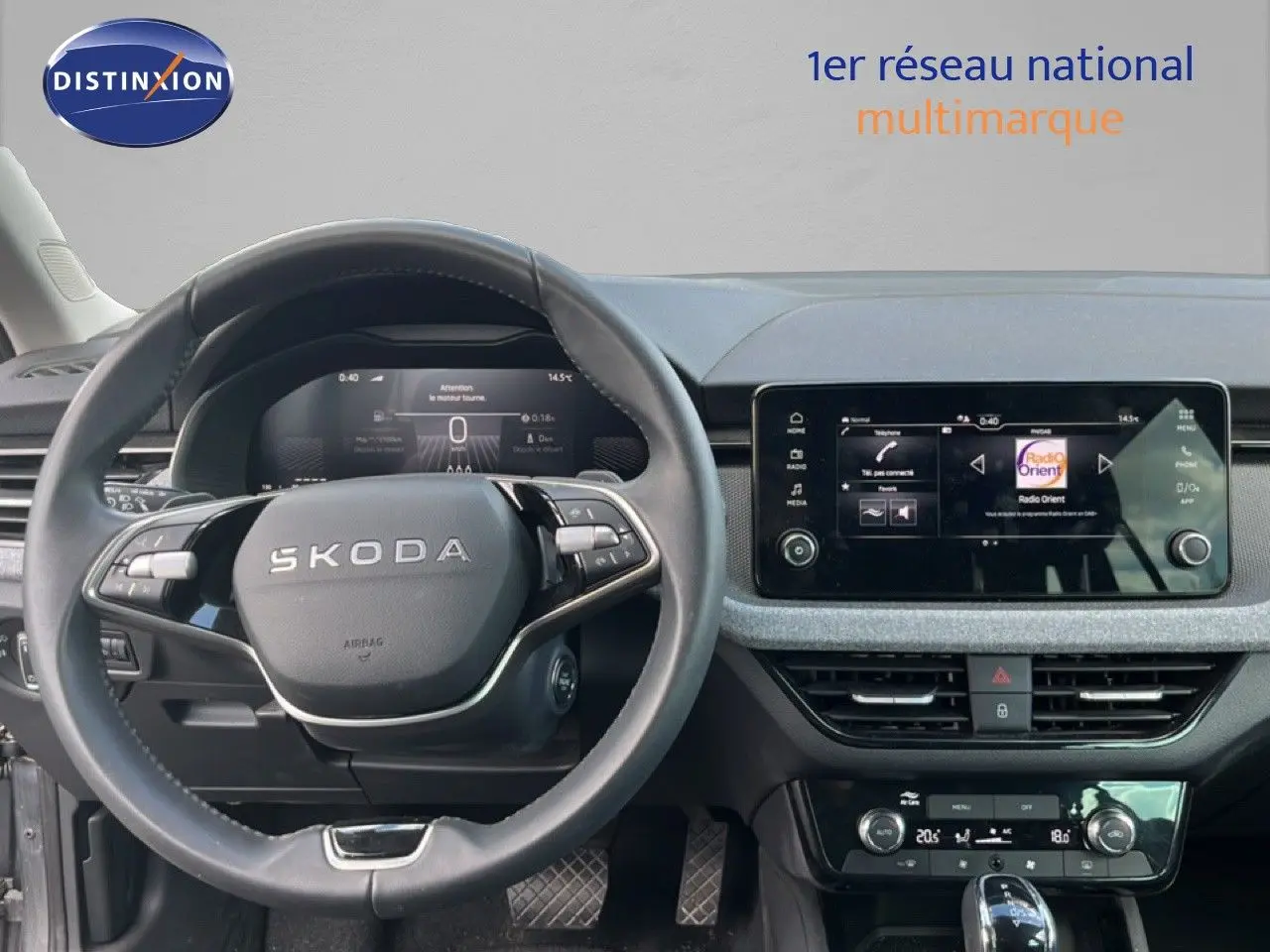 Vue intérieure frontale du tableau de bord gris noir d'une Skoda Scala 2025 avec volant multifonction et écran tactile central.