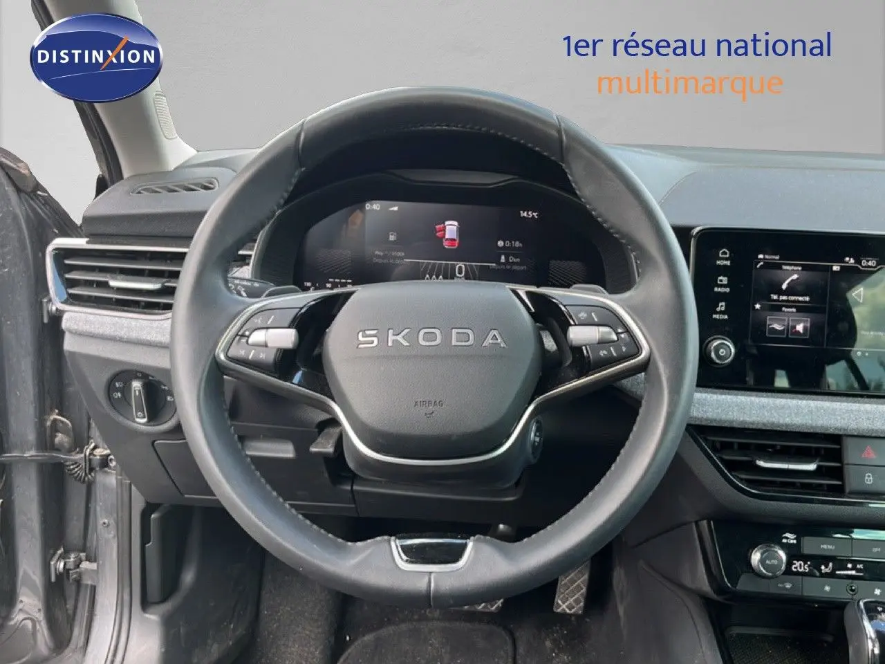 Vue intérieure centrée sur le volant SKODA d'une Scala 2025, avec tableau de bord digital et écran tactile gris magnétique.