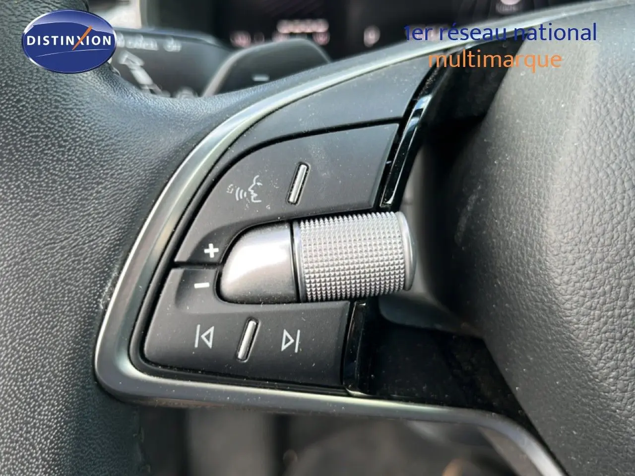 Gros plan sur les commandes multifonctions en métal et plastique noir du volant d'une Skoda Scala gris magnétique 2025.