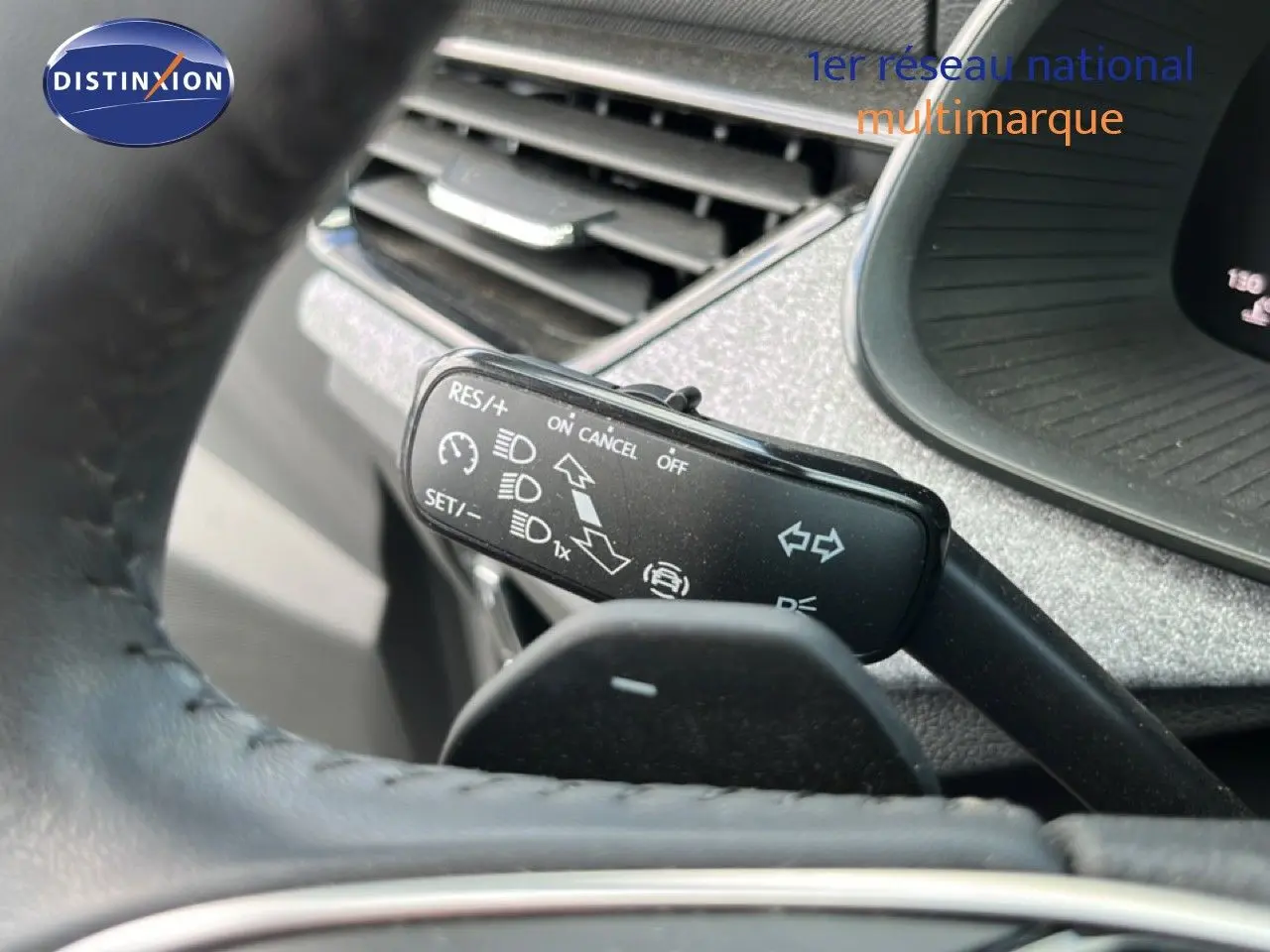 Gros plan sur la commande de régulateur de vitesse dans l'habitacle gris noir d'une Skoda Scala 2025.