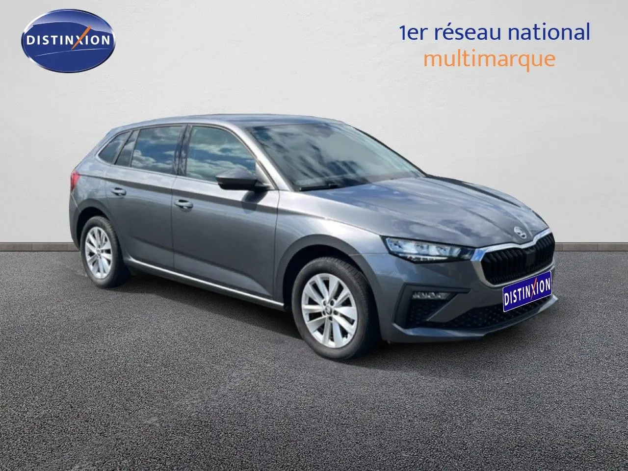 SKODA SCALA gris magnétique métal vue 3/4 avant droit, avec calandre noire et jantes argentées.