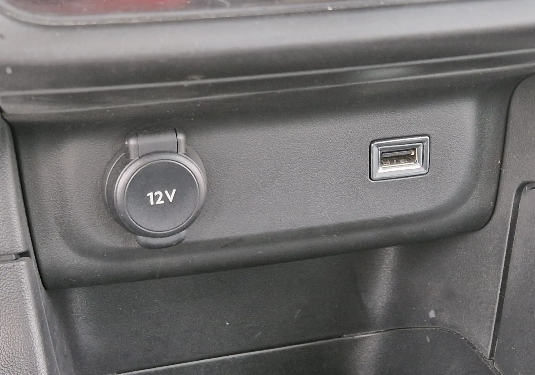 Prise 12V et port USB en gros plan sur la console centrale intérieure d'une Citroën C3 Société blanche.
