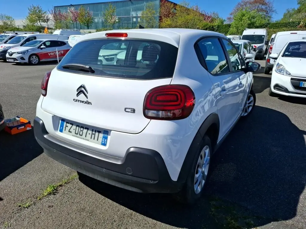Vue 3/4 arrière droite d'une Citroën C3 Société blanche de 2021 avec feux arrière distinctifs et pare-chocs noir.