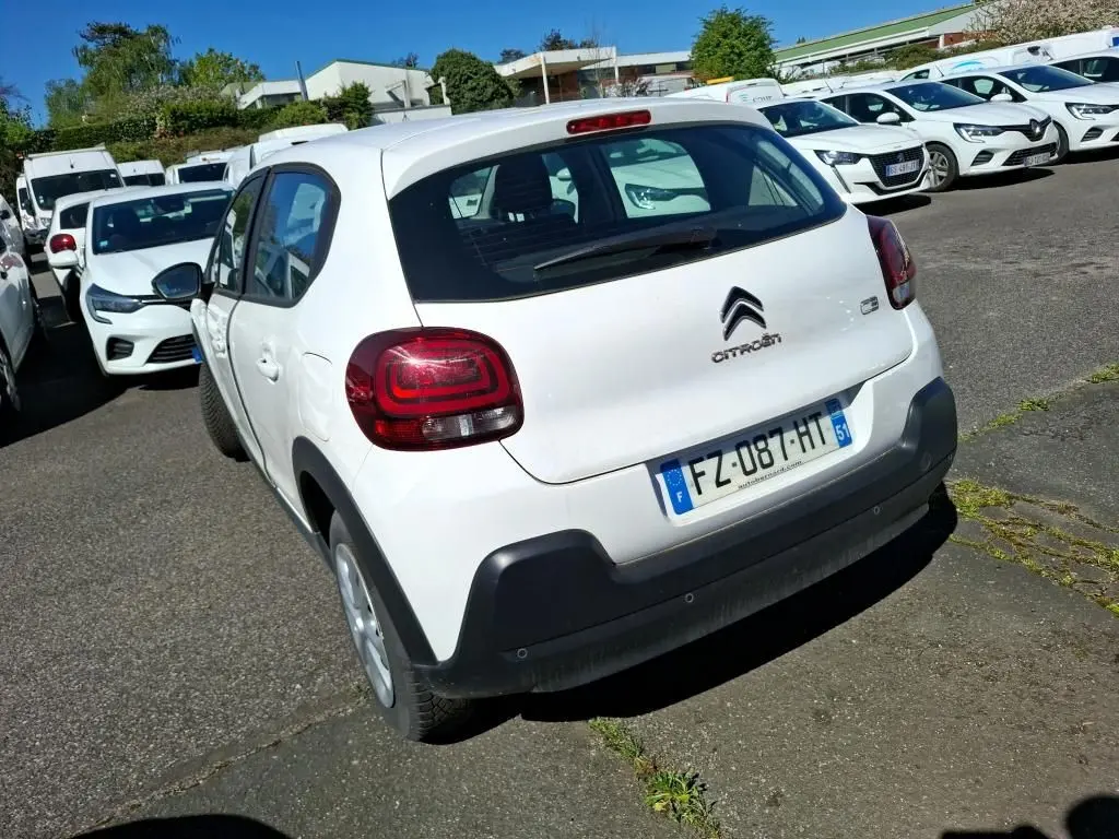 Vue 3/4 arrière droite d'une Citroën C3 Société blanche avec feux arrière distinctifs et pare-chocs noir.