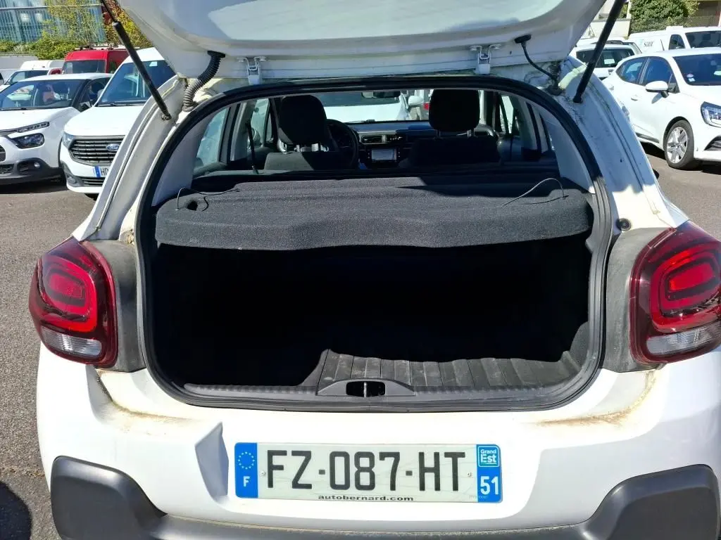 Vue arrière ouverte d'une Citroën C3 Société blanche de 2021, coffre vide et hayon levé en extérieur.