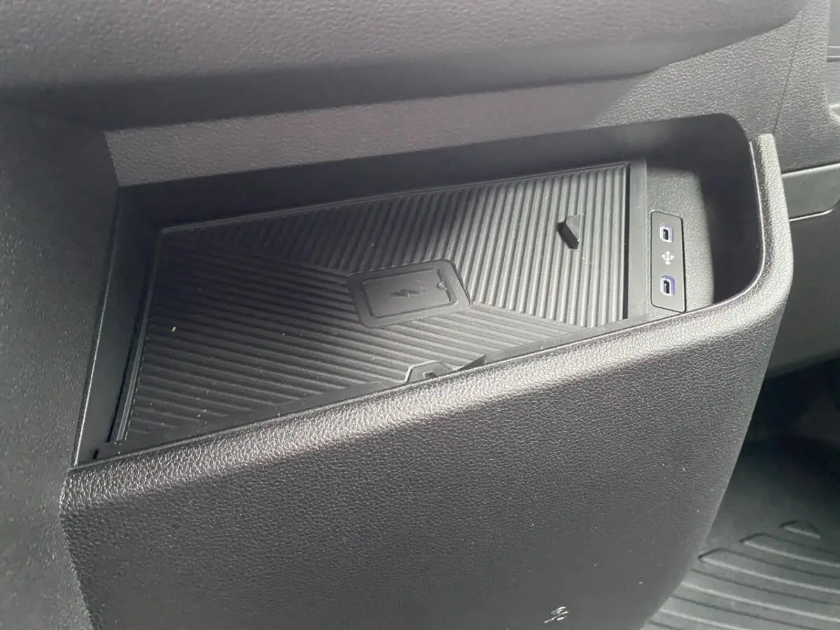 Gros plan sur la zone de recharge par induction et ports USB avant du Renault Master 2026, intérieur noir.