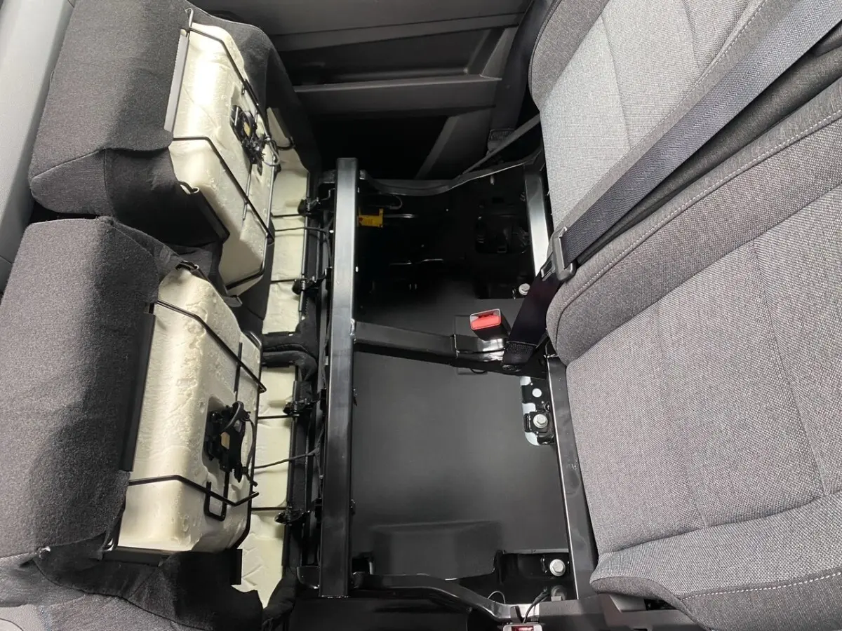 Vue rapprochée de l'intérieur arrière du Renault Master blanc, montrant les sièges rabattus et la structure métallique.