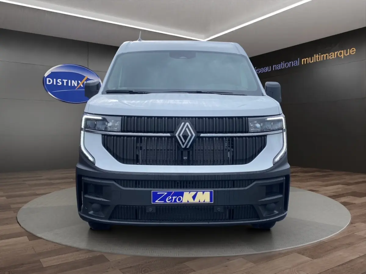 Vue de face du Renault Master blanc avec calandre noire et phares LED, présenté en showroom multimarque.