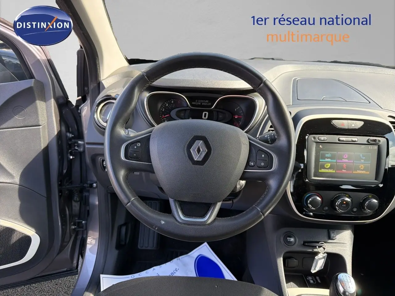 Vue intérieure centrée sur le volant Renault d’un Captur gris Cassiopée 2019 avec tableau de bord et écran tactile visibles.