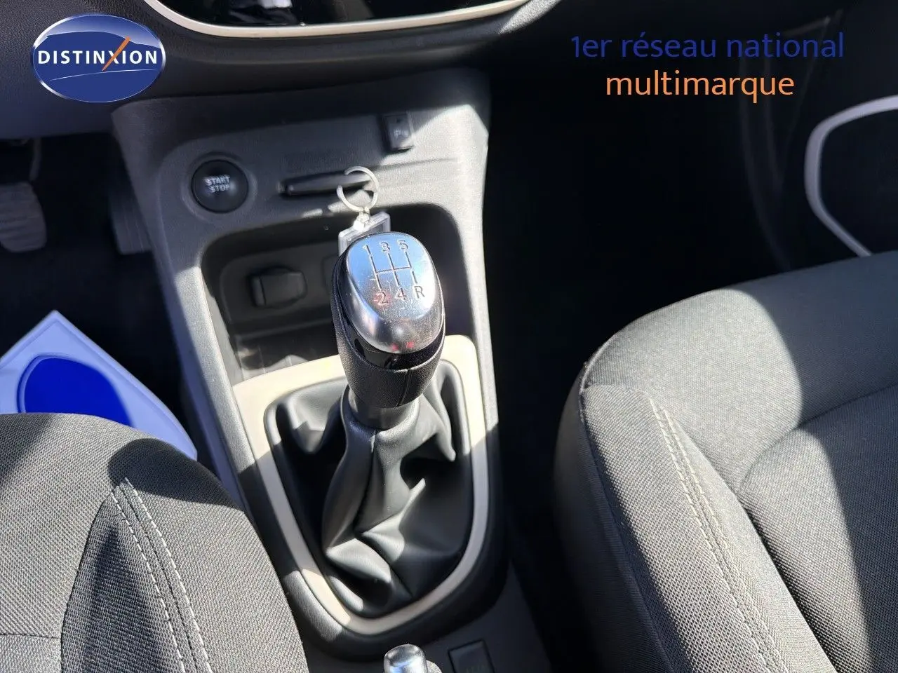 Gros plan sur la console centrale du Renault Captur gris cassiopée, mettant en valeur le levier de vitesse manuel et les sièges tissu noir.