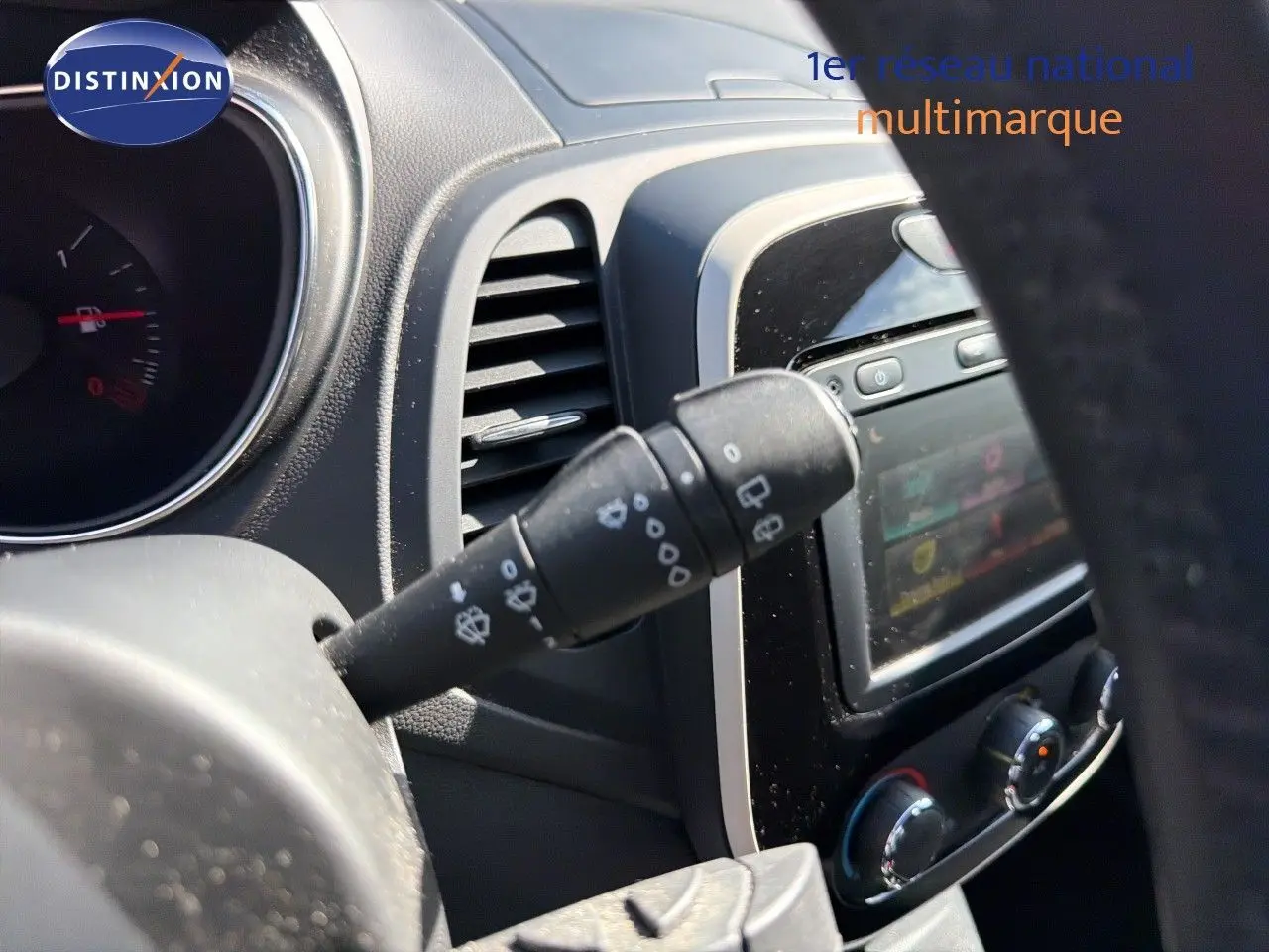 Détail intérieur du Renault Captur gris Cassiopée 2019, montrant la commande d’essuie-glace côté gauche et la console centrale.