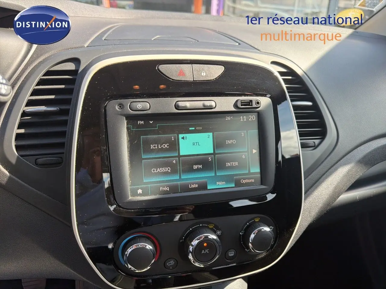 Vue rapprochée du tableau de bord du Renault Captur gris Cassiopée 2019, avec écran tactile et commandes climatisation.