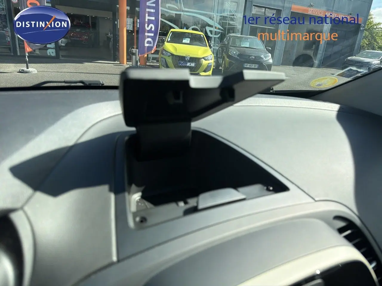 Vue intérieure du tableau de bord du Renault Captur gris Cassiopée 2019, avec boîte manuelle, montrant un rangement ouvert.
