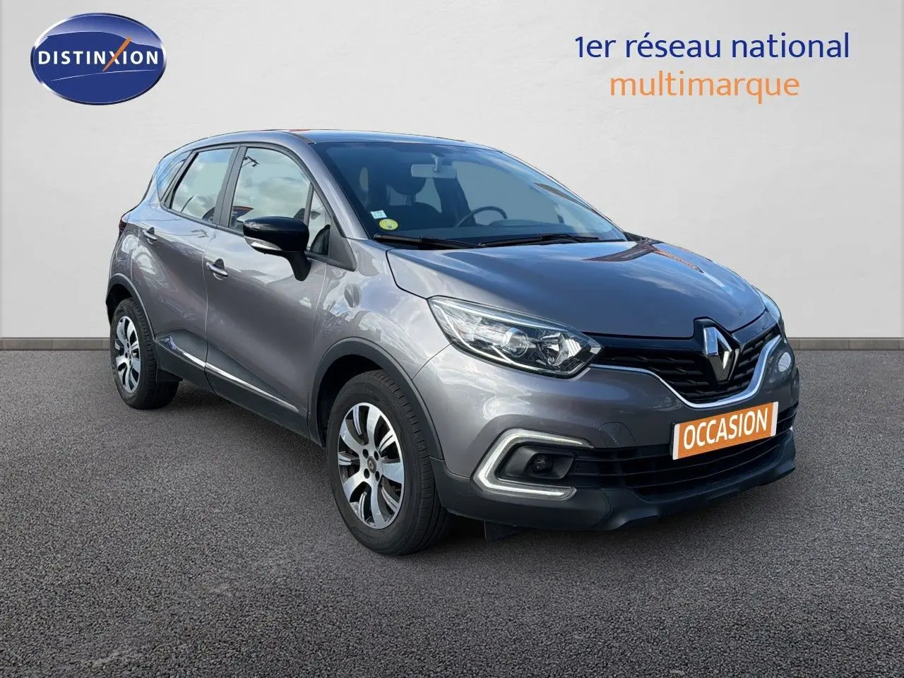Renault Captur Zen gris Cassiopée en 3/4 avant droit, avec jantes bi-ton et calandre noire distinctive.