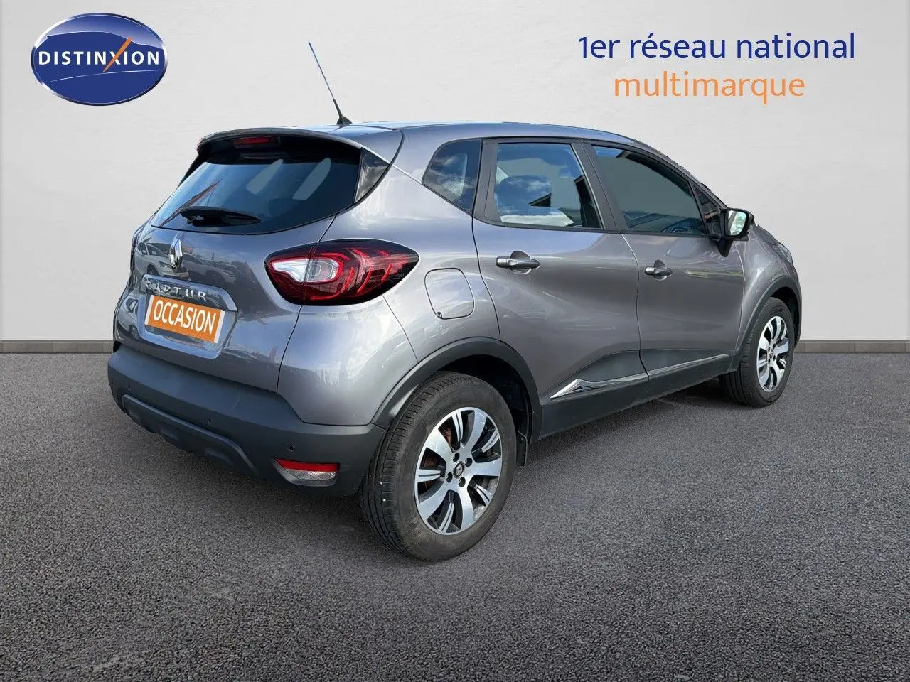 Vue 3/4 arrière droite d'un Renault Captur gris Cassiopée 2019 avec jantes alliage bicolores et vitres teintées.