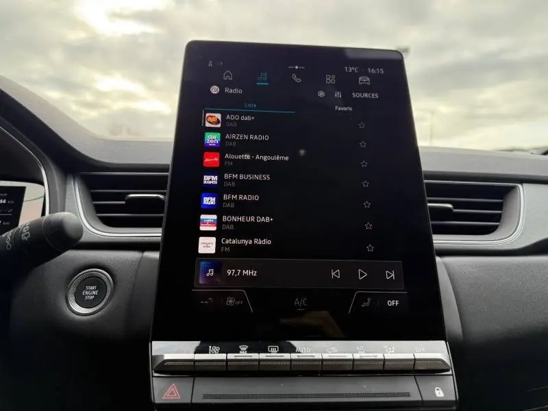 Vue intérieure centrée sur l'écran tactile du tableau de bord du Renault Captur 2025, affichant les options radio numériques.
