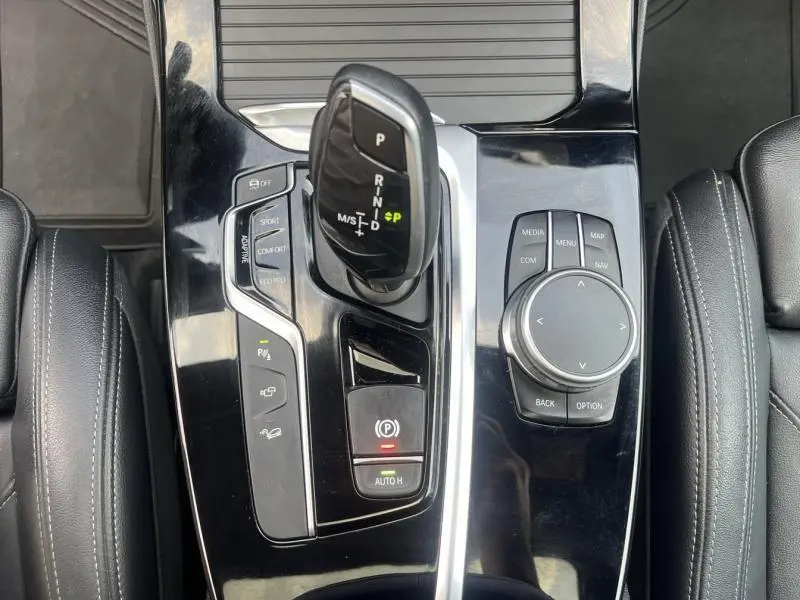 Gros plan sur la console centrale noire brillante du BMW X3 M40i 2019, avec levier de vitesses et commandes multimédia.