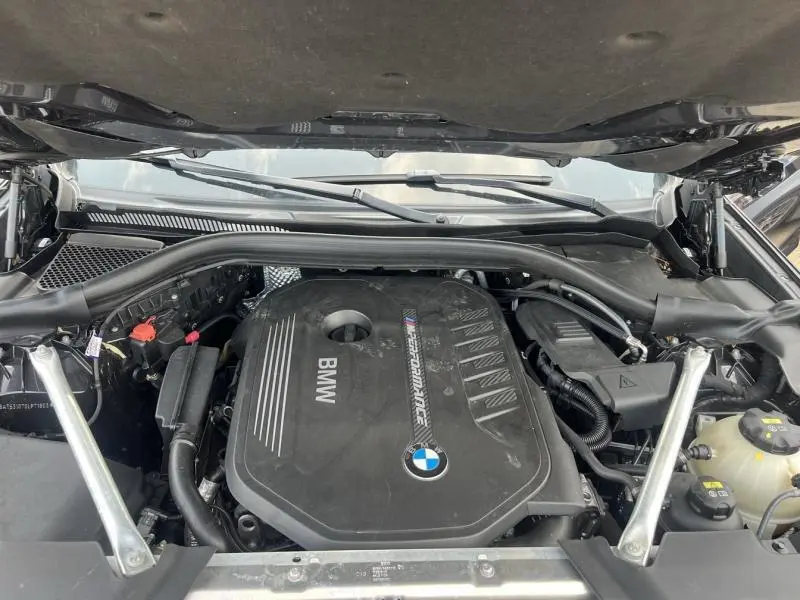 Vue rapprochée du moteur BMW M Performance sous le capot ouvert d'un X3 Sophistograu métallisé de 2019.