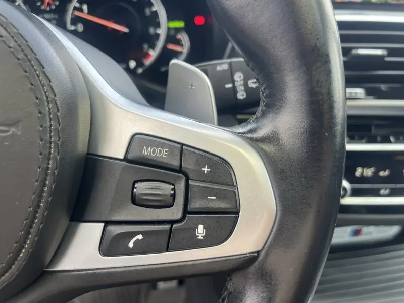 Gros plan sur les commandes au volant cuir noir du BMW X3 M40iA 2019, avec molette et boutons multifonctions.