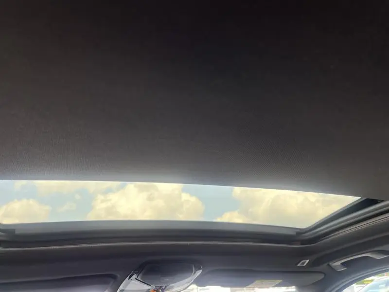 Toit ouvrant panoramique ouvert sur ciel nuageux dans l'habitacle d'un BMW X3 Sophistograu métallisé 2019