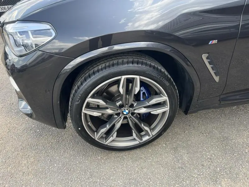 Gros plan sur la roue avant gauche et la jante 21 pouces BMW style 726 en V du BMW X3 M40iA Sophistograu métallisé.