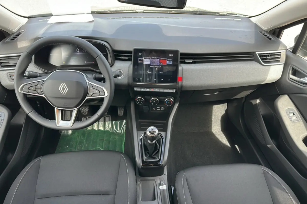 Vue intérieure avant de la Renault Clio DCI 100 Evolution Camera 2025 avec tableau de bord noir et boîte manuelle.