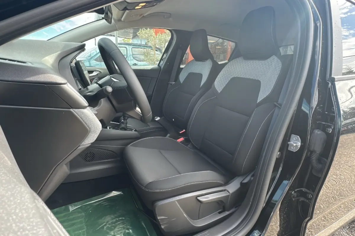 Intérieur de la Renault Clio DCI 100 Evolution Camera 2025, vue côté conducteur, sièges noirs avec inserts gris clair.