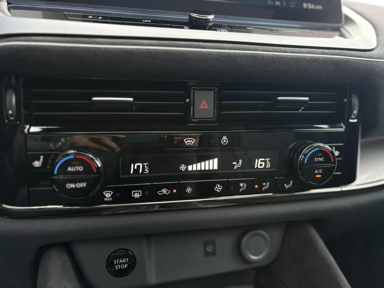 Tableau de bord du Nissan Qashqai 2025 avec commandes climatisation bi-zone et bouton start/stop en vue rapprochée.