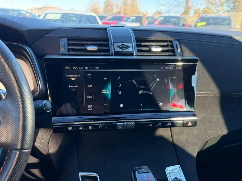 Vue intérieure centrée sur l'écran tactile et la console du DS7 E-TENSE 225ch Performance Line gris Titane 2024.