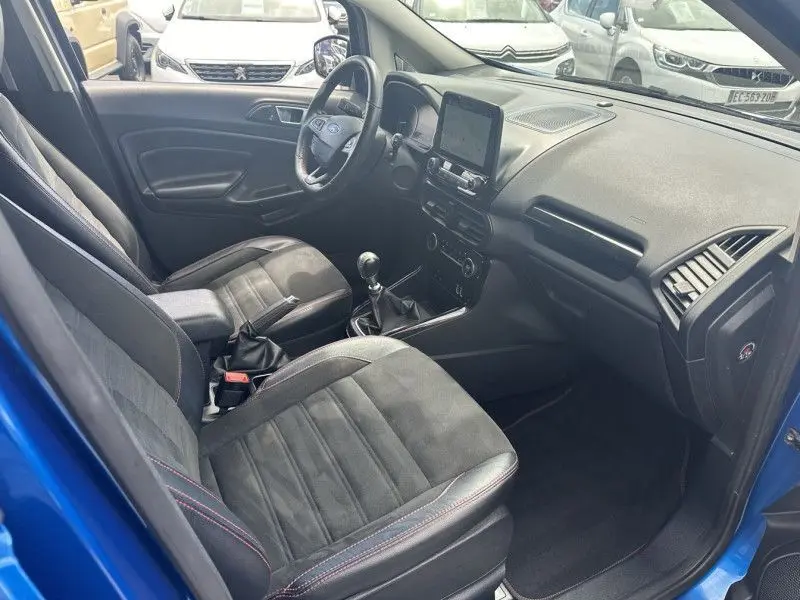 Vue intérieure côté conducteur du Ford Ecosport bleu métal 2018, avec sièges en tissu noir et console centrale équipée d'un écran tactile.