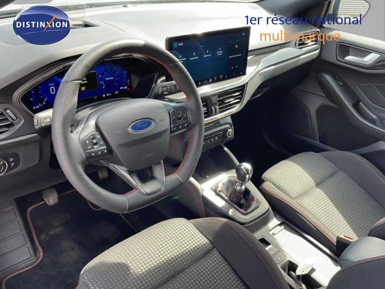 Vue intérieure avant droite de la Ford Focus SW 2023, volant cuir noir, tableau de bord numérique et console centrale avec boîte manuelle.