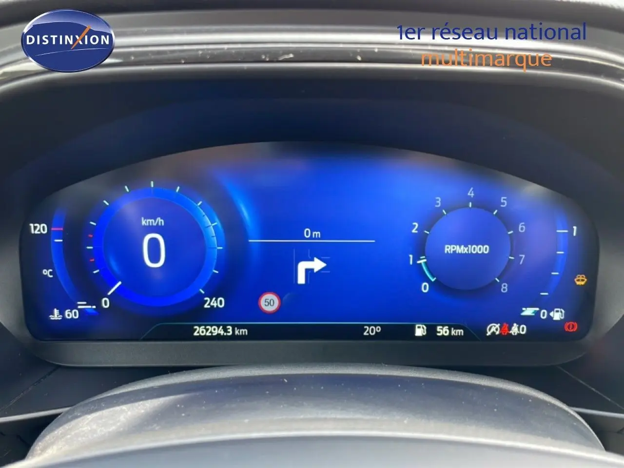 Vue rapprochée du tableau de bord numérique bleu de la Ford Focus SW gris lunaire, affichant vitesse et compte-tours.