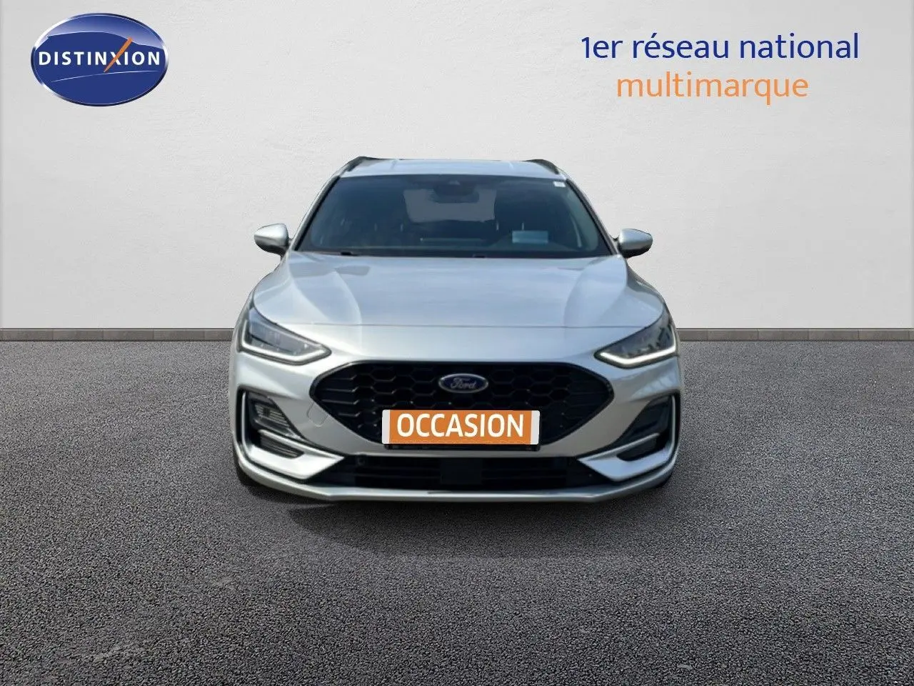 Vue avant d'une Ford Focus SW gris lunaire métal avec calandre noire et plaque "OCCASION" visible.